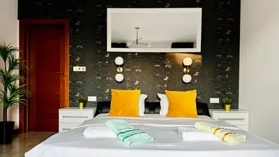 a bedroom with a large bed with yellow pillows at APARTELLO Modern Apartments - CASA REAL in Sveti Vlas in Sveti Vlas