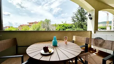 a wooden table with a bowl of fruit on a balcony at APARTELLO Modern Apartments - CASA REAL in Sveti Vlas in Sveti Vlas