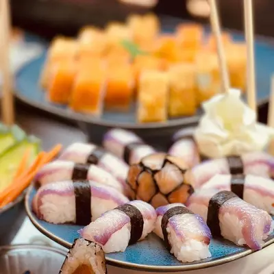 a plate of sushi on a table with other desserts at HVD Clubhotel Miramar - 24 Hours Ultra All Inclusive & Free Parking in Obzor