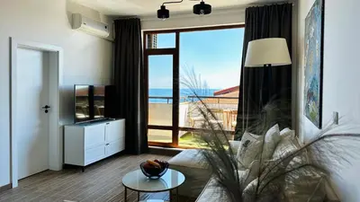 a living room with a couch and a large window at APARTELLO Modern Apartment - Garden of Eden in Sveti Vlas