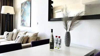 a living room with a couch and a table with a vase at APARTELLO Modern Apartment - Garden of Eden in Sveti Vlas