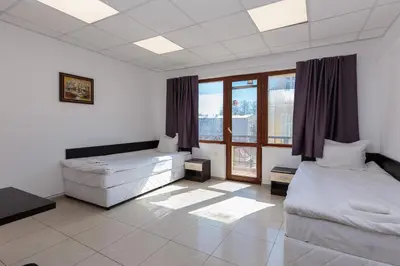 a large room with two beds and a window at СТАИ ЗА ГОСТИ ХАН КРУМ in Burgas City