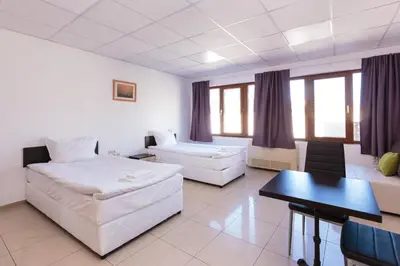 a bedroom with a bed and a table and a couch at СТАИ ЗА ГОСТИ ХАН КРУМ in Burgas City