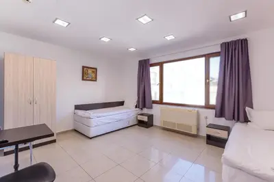 a bedroom with a bed and a couch and a desk at СТАИ ЗА ГОСТИ ХАН КРУМ in Burgas City