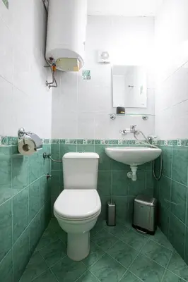 a bathroom with a toilet and a sink at Hotel Albatros New Town in Sozopol