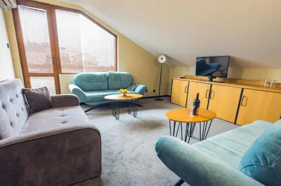 a living room with a couch and chairs and a tv at Hotel Albatros New Town in Sozopol