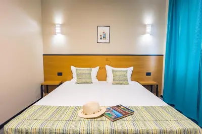 a bedroom with a bed with a hat on it at Hotel Albatros New Town in Sozopol
