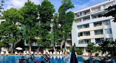 a hotel with a swimming pool in front of a building at Niko Apartments in Sunny Beach