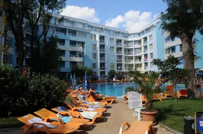 a hotel with lounge chairs and a swimming pool at Niko Apartments in Sunny Beach