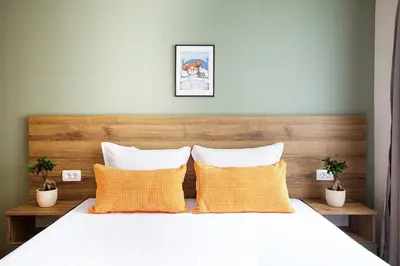 a bedroom with a bed with two yellow pillows at Hotel Albatros Old Town in Sozopol