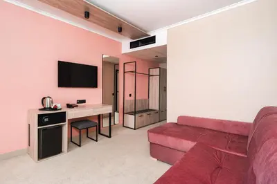 a living room with a red couch and a desk at Festa Panorama Hotel in Nesebar