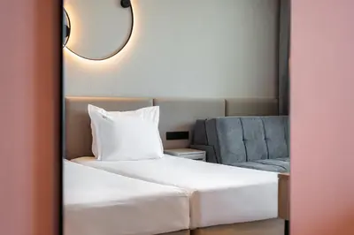 a bedroom with a white bed and a chair at Festa Panorama Hotel in Nesebar