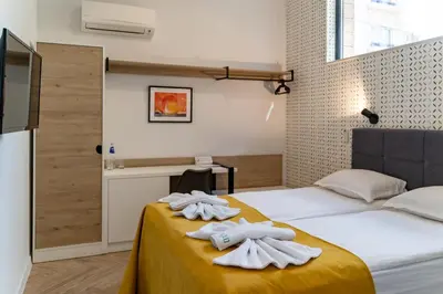 a bedroom with two white towels on a bed at Family Hotel LAXO in Obzor