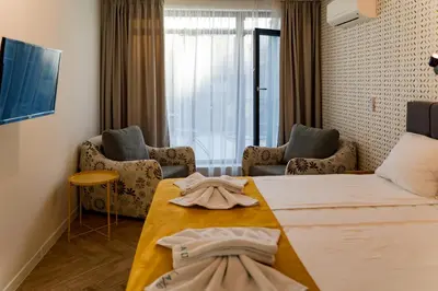 a room with a bed and a table and chairs at Family Hotel LAXO in Obzor