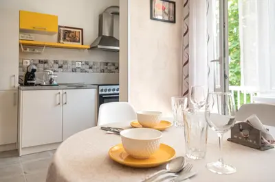 a kitchen with a table with plates and glasses on it at Photo Art apartment in Burgas City