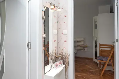 a room with a mirror and a shelf with flowers at Photo Art apartment in Burgas City