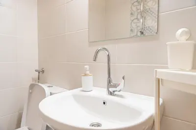 a white bathroom with a sink and a toilet at Photo Art apartment in Burgas City