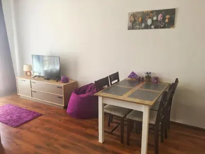 a dining room with a table and chairs and a tv at Byala Apartments BSR 7 in Byala