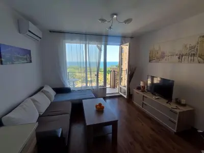 a living room with a couch and a tv at Byala Apartments BSR 7 in Byala