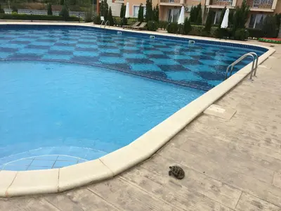a large blue swimming pool with a checkerboard pattern at Byala Apartments BSR 7 in Byala