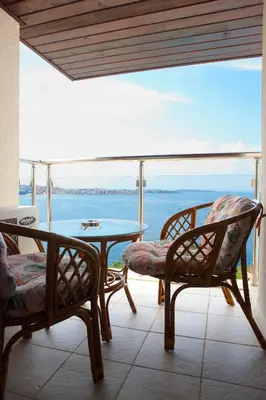 a patio with a table and chairs and a view of the ocean at Apartments 