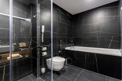 a bathroom with a toilet and a bath tub at Hotel Bulgaria in Burgas City