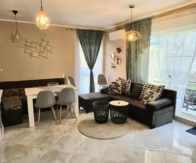 a living room with a couch and a table at GG Garden Deluxe in Chernomorets
