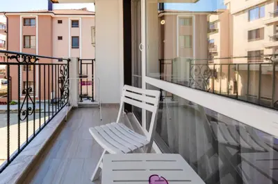 a balcony with a rocking chair on a balcony at Guest House Theona in Obzor