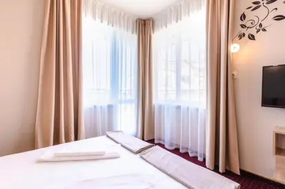 a bedroom with a bed and a large window at Guest House Theona in Obzor
