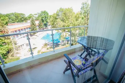 a balcony with a table and a view of a pool at MNG Holiday Yassen Apartments in Sunny Beach