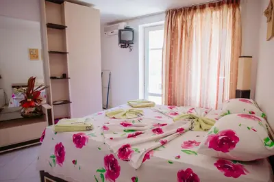 a bedroom with a bed with pink flowers on it at MNG Holiday Yassen Apartments in Sunny Beach