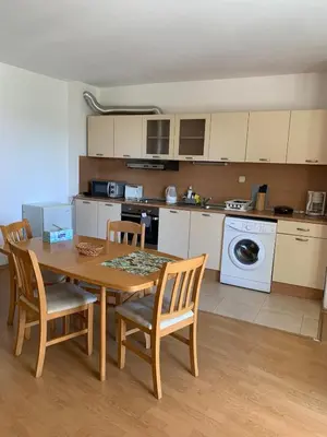 a kitchen with a table and chairs and a kitchen with a washing machine at MNG Holiday Yassen Apartments in Sunny Beach