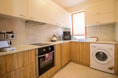 a kitchen with a washing machine and a washer at Penthouse at White Cliffs in Byala