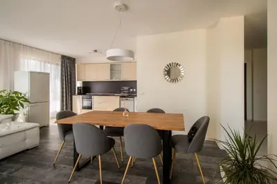 a kitchen and dining room with a wooden table and chairs at Penthouse at White Cliffs in Byala
