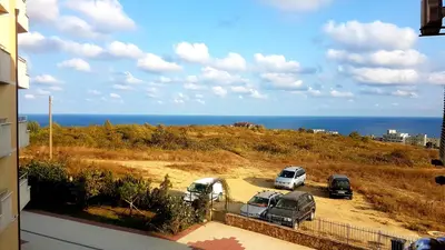a view of cars parked in a parking lot with the ocean at Apartments Paskalina in Byala