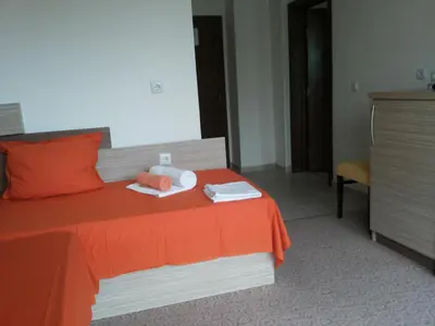 a hotel room with a bed with orange sheets and towels at Family Hotel Golden Lion in Primorsko
