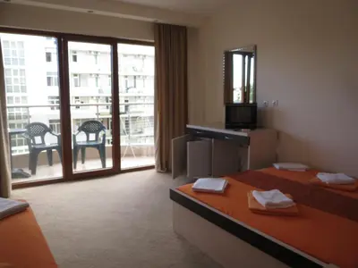 a hotel room with two beds and a balcony at Family Hotel Golden Lion in Primorsko