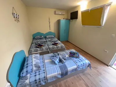 two beds in a small room with a tv at Villa SUN in Kiten