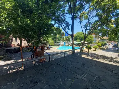 a swimming pool in a park with trees at хотел Централ in Sozopol