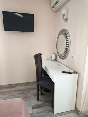 a room with a white desk with a chair and a mirror at Palma in Burgas City
