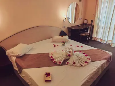 a hotel room with a bed with two wedding towels at Palma in Burgas City