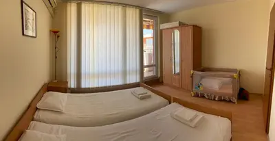a room with two beds and a window with a window at Nessebar Fort Club Apartment 226 in Sunny Beach