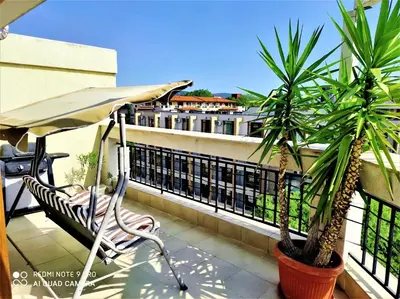 a balcony with a chair and palm trees and an umbrella at Diamond Palace in Sunny Beach
