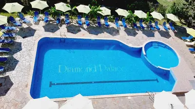 a large swimming pool with blue lounge chairs and a swimming pool at Diamond Palace in Sunny Beach