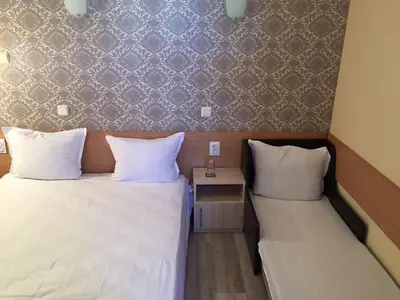 two beds in a room with two pillows and a table at Guest House Afrodita in Chernomorets