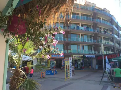 a large building with people walking in front of it at Briz Beach Apartments in Sunny Beach