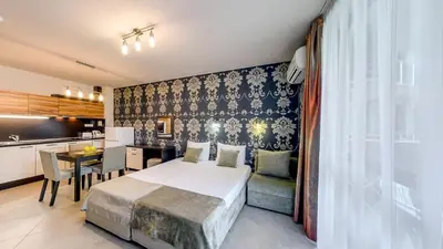 a hotel room with a bed and a kitchen at Briz Beach Apartments in Sunny Beach