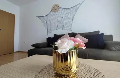 a gold vase with flowers on a table in a living room at New Line Village Apartments in Sunny Beach