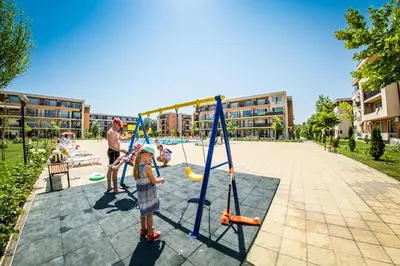 a couple of children playing a game in a park at Holiday and Orchid Fort Noks Apartments in Sunny Beach
