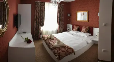 a bedroom with a large bed with red walls at Golden House in Varna City